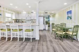 cocina con armarios blancos, mesa y sillas en Sunset Villas 2, en Clearwater Beach