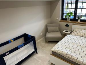 ein Schlafzimmer mit einem Bett, einem Stuhl und einem Fenster in der Unterkunft Ferienwohnung Plan B in Lörrach