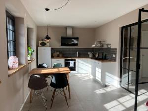 a kitchen with a table and some chairs in a room at Neubau im Loft-Stil mit großer Terrasse in Lörrach