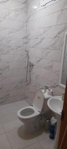 a white bathroom with a toilet and a sink at Aluguer apartamento in Santa Maria
