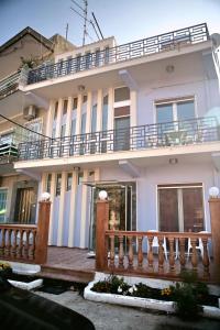a white house with a wooden fence in front of it at TARLAS ROOMS in Mytilene