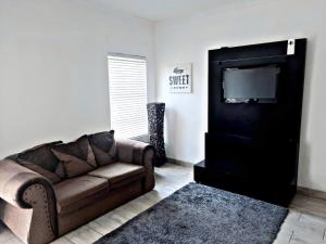 sala de estar con sofá y TV de pantalla plana en Feel@Home, en Ciudad del Cabo