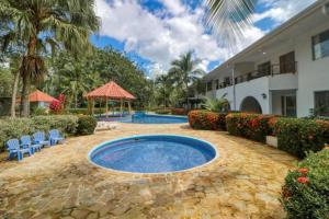 a resort with a swimming pool and a building at Lovely Condo (8 people): Pools, Tennis Courts, BBQ in Manuel Antonio