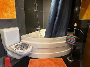 een badkamer met een toilet en een bad met een douche bij Hadassa New York in Steffisburg