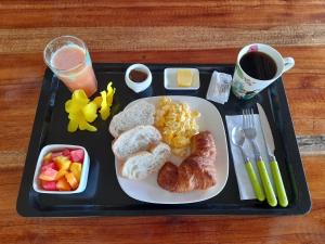 a tray with a plate of breakfast food and a drink at Hotel El Colibri Rojo - Cabinas - Le Colibri Rouge in Cahuita
