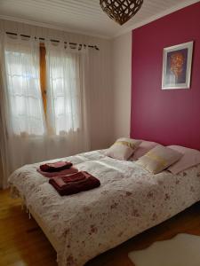 1 dormitorio con 1 cama grande y pared morada en Chambre Zen à la campagne, en Marennes