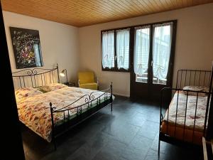 Schlafzimmer mit einem Bett, einem Stuhl und Fenstern in der Unterkunft Hadassa New York in Steffisburg