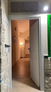 un corridoio con porta bianca e una stanza con lampada di Dimora Vesuviana a Ercolano