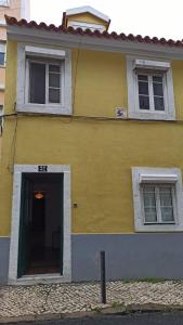 żółty dom z drzwiami i dwoma oknami w obiekcie Ocean Corner Belém w Lizbonie