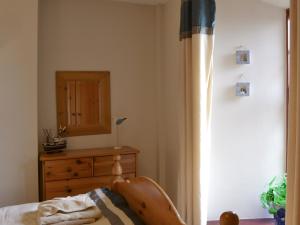 een slaapkamer met een bed, een dressoir en een spiegel bij Low Tide in Cellardyke