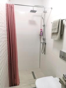 a shower with a red shower curtain in a bathroom at White Studio in Câmpulung Moldovenesc