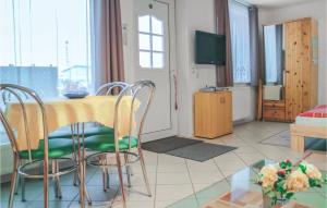 ein Wohnzimmer mit einem Tisch, Stühlen und einem TV in der Unterkunft Amazing Apartment In Elmenhorst With Kitchen in Elmenhorst