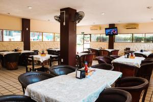 a restaurant with tables and chairs and a television at Hotel Gina in Tecomán