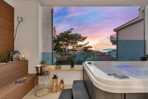a bath tub in a room with a window at The Luxury Goldenhour in Makarska