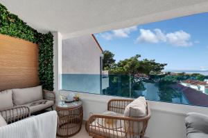 a balcony with a couch and chairs and a large window at The Luxury Goldenhour in Makarska