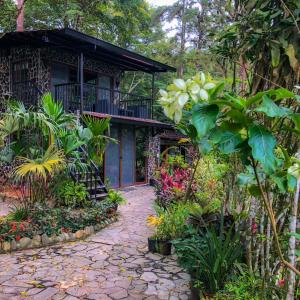 einen Garten vor einem Haus mit Blumen in der Unterkunft Cabañas Lago Cerro Azul - Lake of Panama in Cerro Azul