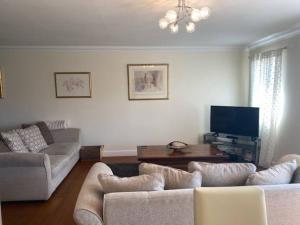 a living room with two couches and a tv at Spacious 2 bedroom apartment Cleethorpes in Cleethorpes