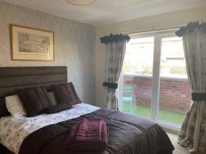 a bedroom with a bed and a large window at Spacious 2 bedroom apartment Cleethorpes in Cleethorpes