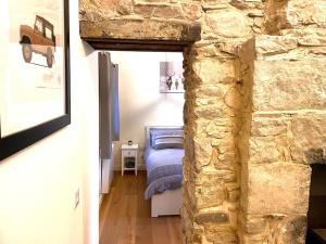 ein Schlafzimmer mit einem Bett und einer Steinmauer in der Unterkunft The Old Croft in Fort Augustus