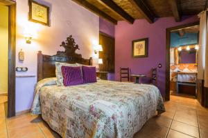 a bedroom with a bed with purple walls at Hotel el Cantón Rural in La Cuba