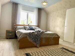 um quarto com uma cama num quarto com uma janela em Lilla Hule - på landet nära sjö em Oskarshamn