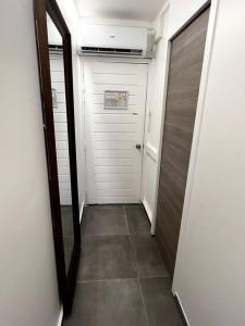 un corridoio con porta bianca e specchio di The Grey Rocks Studio a Le Diamant