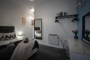 Schlafzimmer mit einem Bett, einem Schreibtisch und einem Spiegel in der Unterkunft Bank Street Apartment 1 in Blackpool