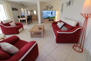 a living room with two red couches and a table at La Cèzenole in Méjannes-le-Clap