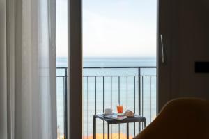 B&B Le Suites di Costanza في تشفالو: غرفة مع طاولة مطلة على المحيط