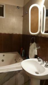 y baño con lavabo, bañera y espejo. en Casa San Rafael Mendoza en San Rafael