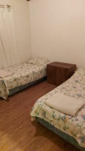 1 dormitorio con 2 camas y suelo de madera en Casa San Rafael Mendoza en San Rafael