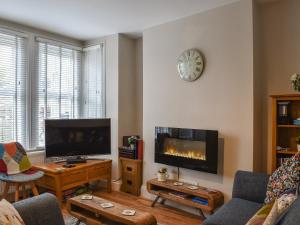 a living room with a tv and a fireplace at Brookdown in Ilfracombe