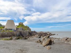 a house on a rocky beach next to the ocean at Brookdown in Ilfracombe