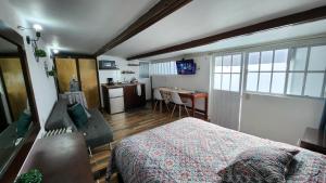 1 dormitorio con 1 cama y cocina con mesa en Depa #6 Tipo Loft en Planta Alta en Centro Histórico en Zacatecas