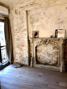 Charming and Design Attic Loft Central Milan in coolest area Navigli Ticinese في ميلانو: غرفة مع موقد حجري مع ميكروويف