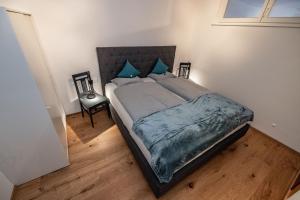 a bedroom with a large bed with blue pillows at Berg Apartment-Berg im Drautal in Berg im Drautal
