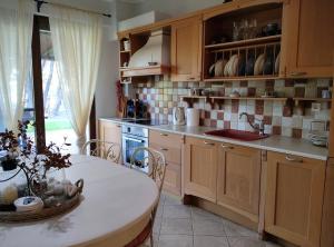 a kitchen with wooden cabinets and a table and a sink at High aesthetics maisonette in the wood by the sea in Metamorfosi +44 photos