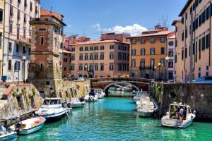 a group of boats docked in a canal with buildings at Il Garibaldino in Livorno