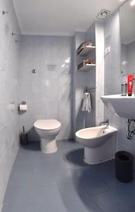 a white bathroom with a toilet and a sink at Il Garibaldino in Livorno