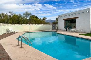 a swimming pool in a yard with chairs next to a building at 4th Street in Tucson