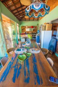 een grote houten tafel in een kamer met een keuken bij Casa com os pés no mar em Iriri ES in Anchieta