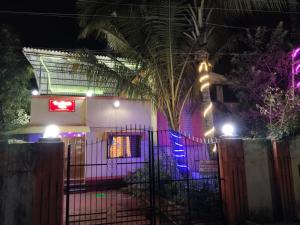 une maison avec une clôture devant elle la nuit dans l'établissement HemHarsh Holiday Home, à Karjat