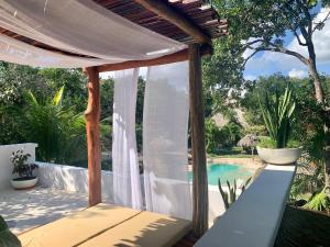 a patio with a white canopy and a swimming pool at Villa Morena Boutique Hotel Ecoliving in Akumal