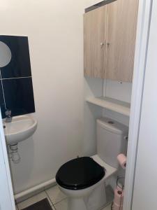 La petite salle de bains est pourvue de toilettes noires et d'un lavabo. dans l'établissement Appartement duplex T3 - Paris Jeux Olympiques - Roissy CDG - Parc des expositions - Disney - Astérix, à Villepinte