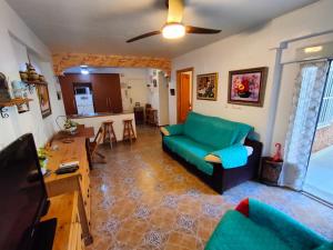 グアルダマル・デル・セグラにあるApartamento Maiteのリビングルーム(緑のソファ付)、キッチンが備わります。