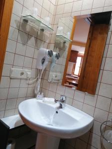 y baño con lavabo blanco y espejo. en Apartaments La Bonaigua, en Valencia de Aneu