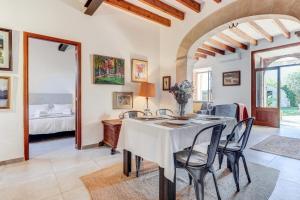 a dining room with a table and chairs and a bedroom at U Vila in Pollença