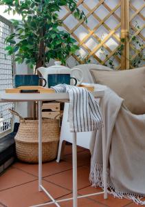 a table and chairs on a balcony with a plant at SUNNY SIDE I Turin Suite in Turin