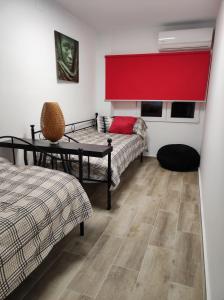 Habitación con 2 camas y cortina roja. en Lille en Provence, en Valencia