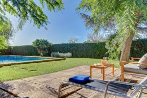 a patio with a table and chairs next to a swimming pool at U Vila in Pollença